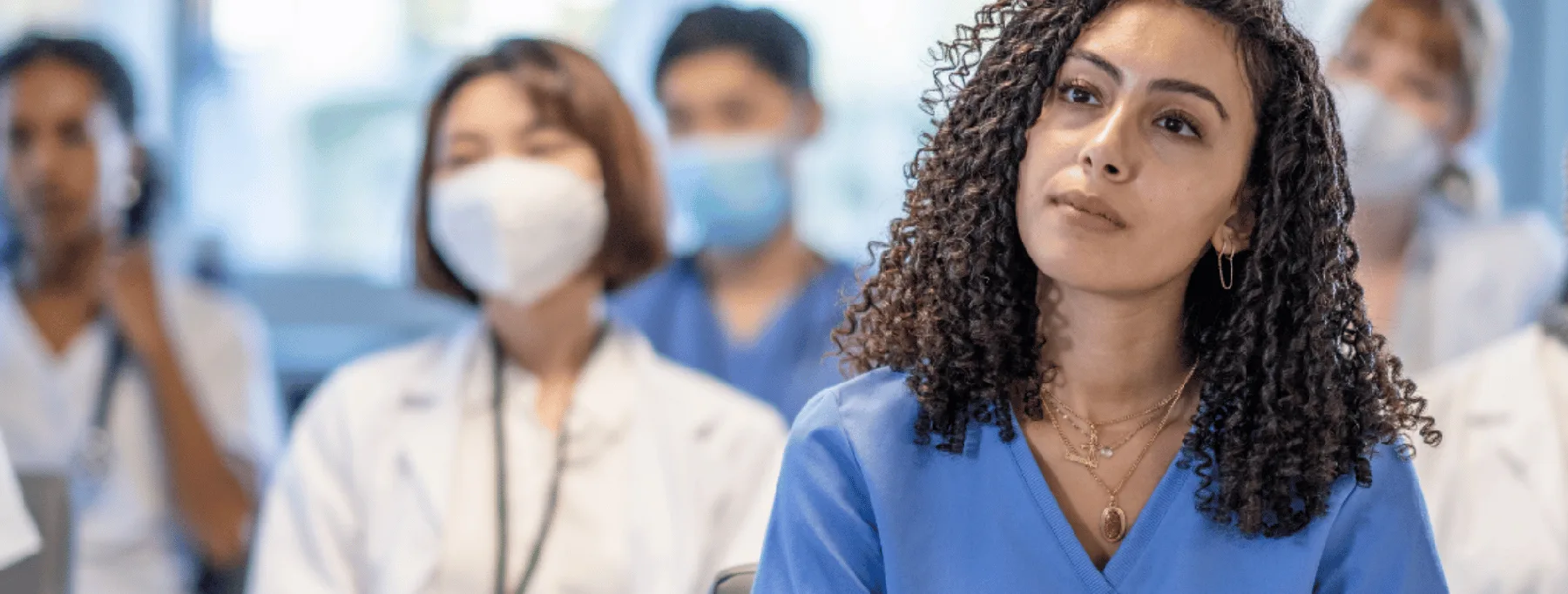 Soignante et équipe masquées à l'écoute d'un patient