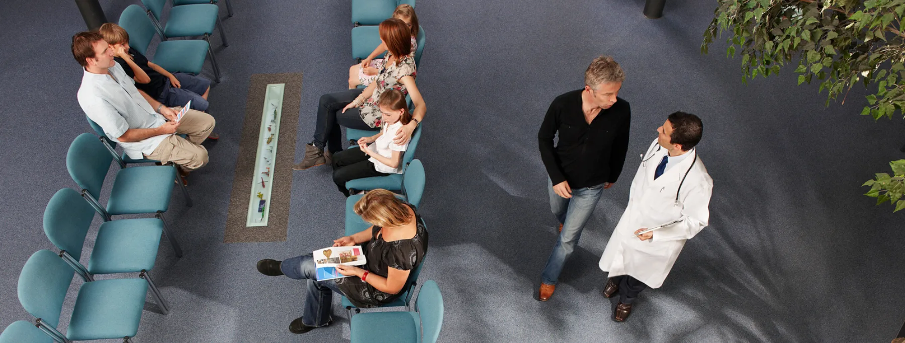 Salle d'attente vue de dessus : patients, accompagnants et médecin